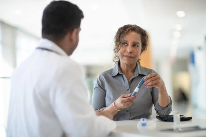 woman consulting with medical doctor over veins treatment